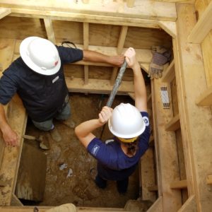 Archaeologist and scientist stand in a well