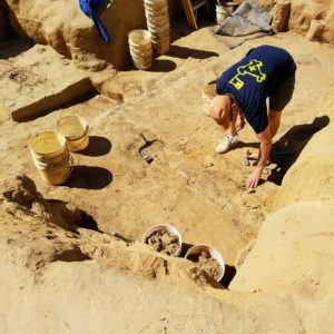 Archaeologist examining a find in an excavation unit