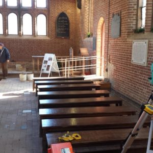 Archaeologist recording with total station in brick church