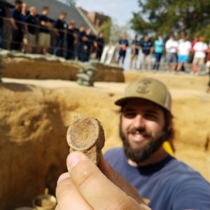 Archaeologist showing shark vertebra to camera