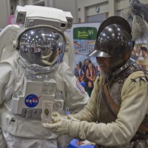 Man in historical armor talks to astronaut in space suit