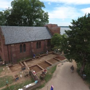 Aerial view of students excavating next to brick church