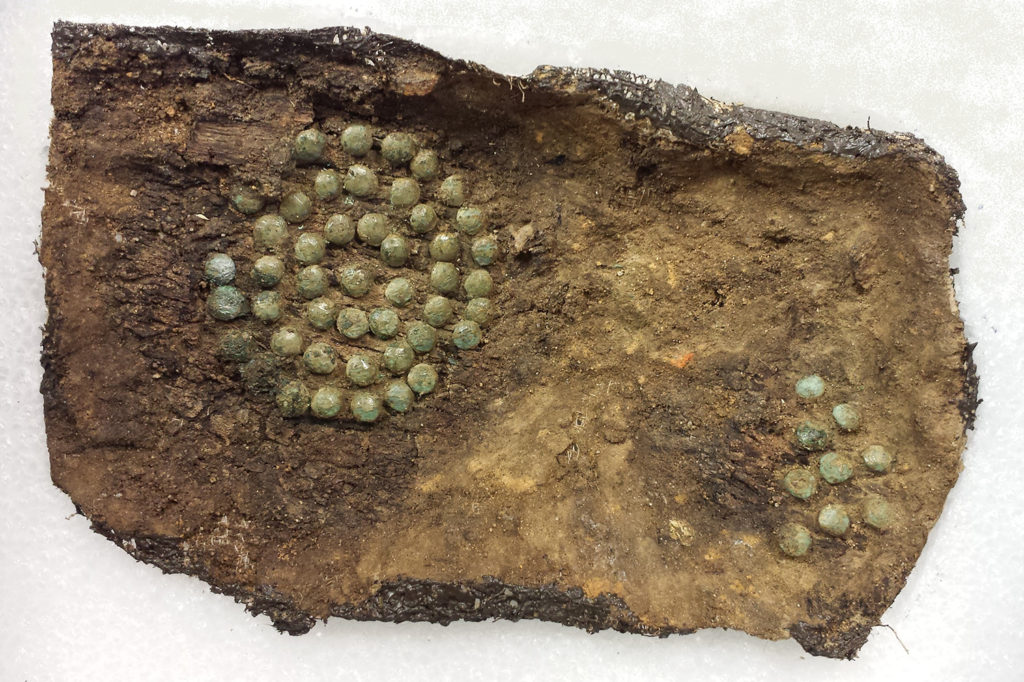 wood fragment with tacks in circular decoration