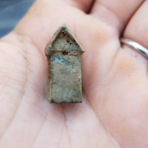 Hand holding small copper alloy windmill