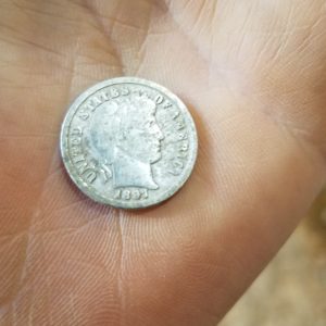 Hand holding 1897 dime