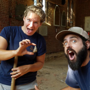 Two archaeologists show megalodon tooth to camera