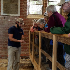 Archaeologist shows excavated box to visitors