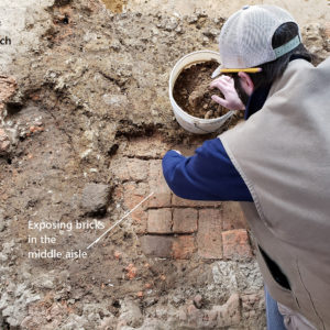 Archaeologist excavates brick floor