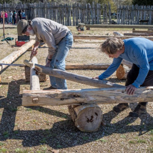 two men assembling a a building frame on the ground