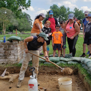 Chardé Reid talks to visitors to the Angela Site while Angie Tomasura removes backfill from the 1930s excavations