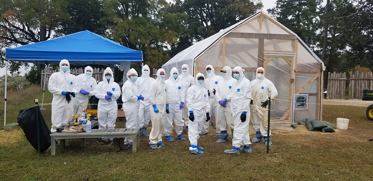 The team in their protective gear outside the burial structure