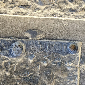 A closeup of the Knight’s Tomb ledger stone showing pry marks from the robbery of its brass inlays.