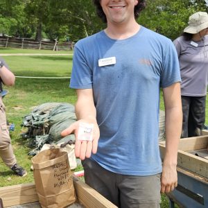 Field School student Calvin Boulier holds a lead seal, probably a 4-part alnage bearing the bust of George I of England.