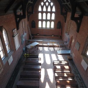 Interior of brick church with wooden pews