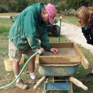 Archaeologist screening for artifacts