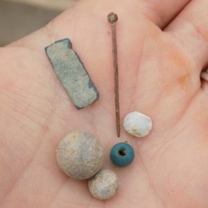 Hand holding an assortment of small artifacts