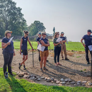 Senior Staff Archaeologist Mary Anna Hartley shares the plan for the 1607 burial ground excavations with the archaeological team.