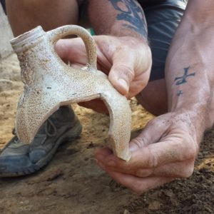 Archaeologist holding half of a Bartmann jug