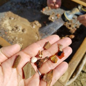 Hand holding an assortment of small artifacts