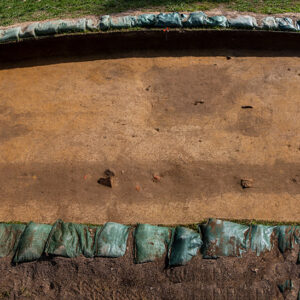 A view of two adjacent squares in the north field. The east/west ditch is clearly visible in the foreground as is the pit feature near the center in the background.