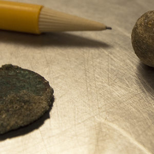 jetton and musket ball next to a pencil for scale