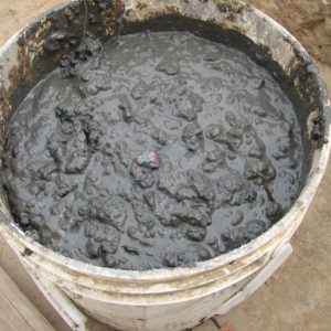 Bead sitting on top of mud in a bucket