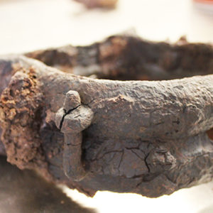 close-up view of a corroded semi-circular iron object