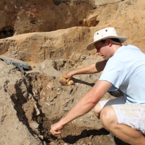 Archaeologist excavating a pile of oyster shells