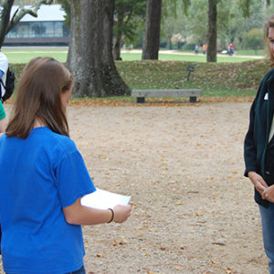 children presenting a paper to a staff member