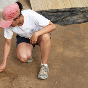 Archaeologist troweling in an excavation unit