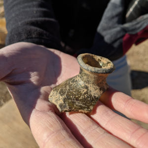 hand holding the broken top of a case bottle