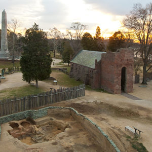 aerial view of a large excavation unit by a brick church