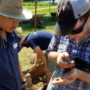 Student holds and photographs an artifact