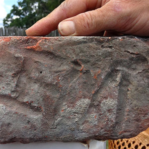 brick with inscribed initials