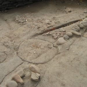 Circular feature outlined between a break in a line of cobblestones