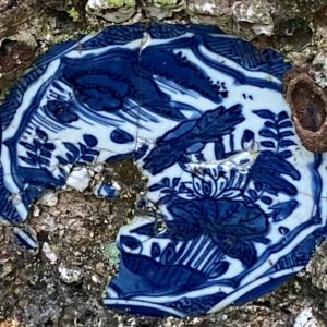 Close up image of a blue and white porcelain plate surrounded by shells in the grotto of the palace of the Marquesses of Fronteira