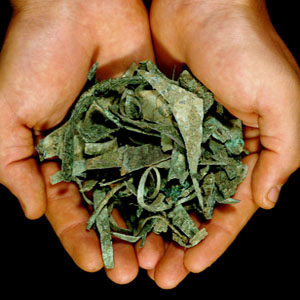 Hands holding an assortment of copper artifacts