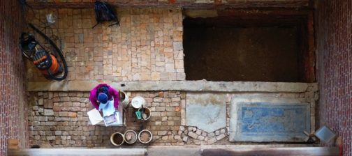 Aerial view of archaeologist documenting excavations in brick church