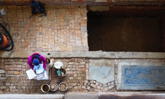 Aerial view of archaeologist documenting excavations in brick church