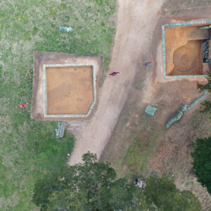 Members of the archaeological team mark the path of the early-fort-period ditch as revealed by ground-penetrating radar. The ditch is easily visible in the left (north) square because it has darker soil than that surrounding it. It is also visible in the left portion of the right square before it is cut by the later well and builder's trench.