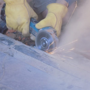 Conservator using electric saw on cement