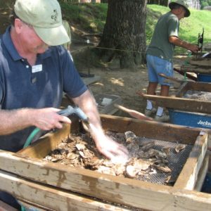 Archaeologist screening artifacts