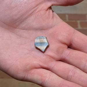 hand holding a ceramic sherd