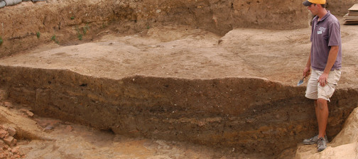 Archaeologist examining excavation unit