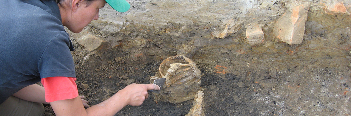 Archaeologist excavating a sword basket hilt