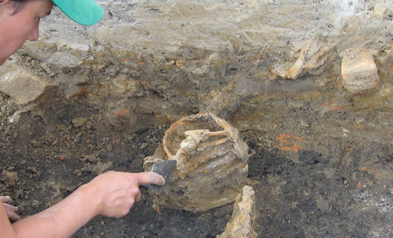 Archaeologist excavating a sword basket hilt