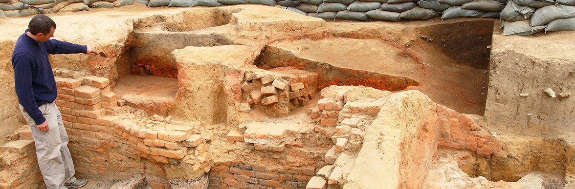 Archaeologists pointing to features in a cellar