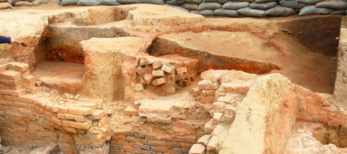 Archaeologists pointing to features in a cellar