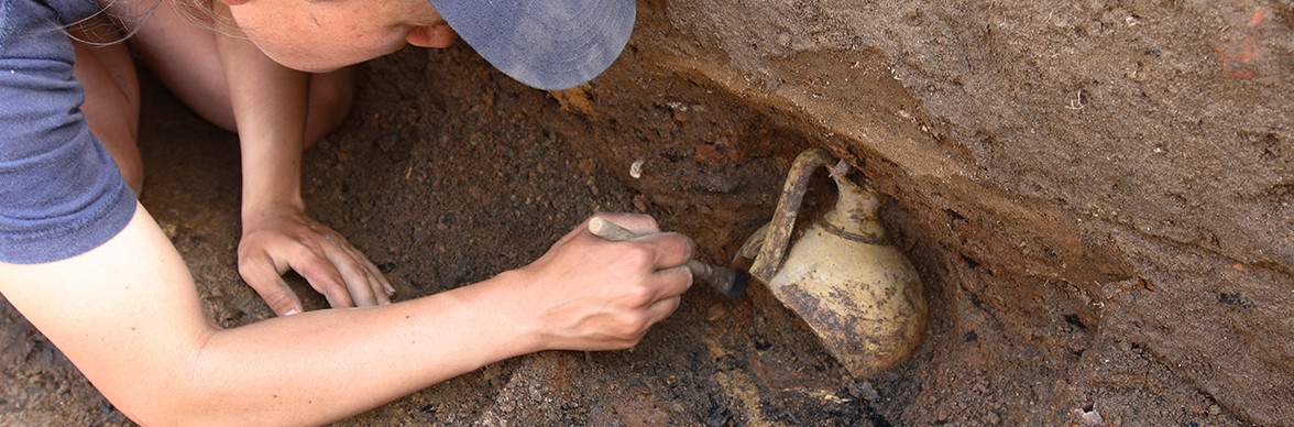 Archaeologist excavating jar