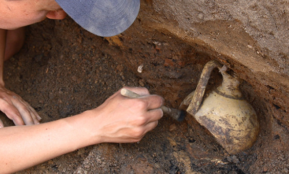 Archaeologist excavating jar